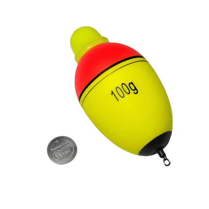 A brightly colored fishing float, primarily yellow with a red top and a black bottom. The float is marked with "100g," indicating its weight. Next to the float is a small coin, providing a size reference. 