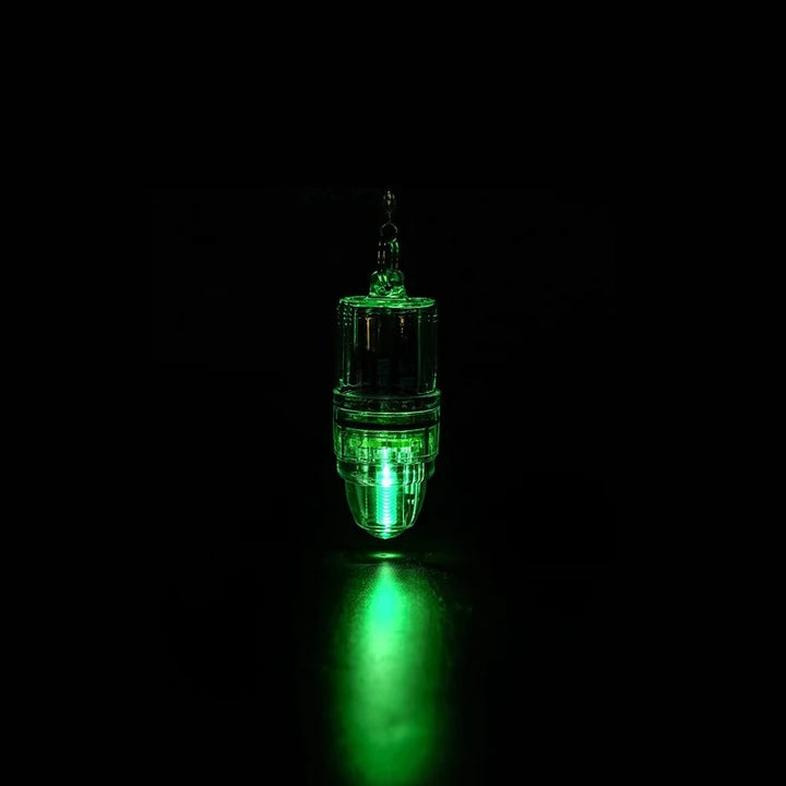 A glowing green fishing light attached against a dark background, illuminating the area below it. 