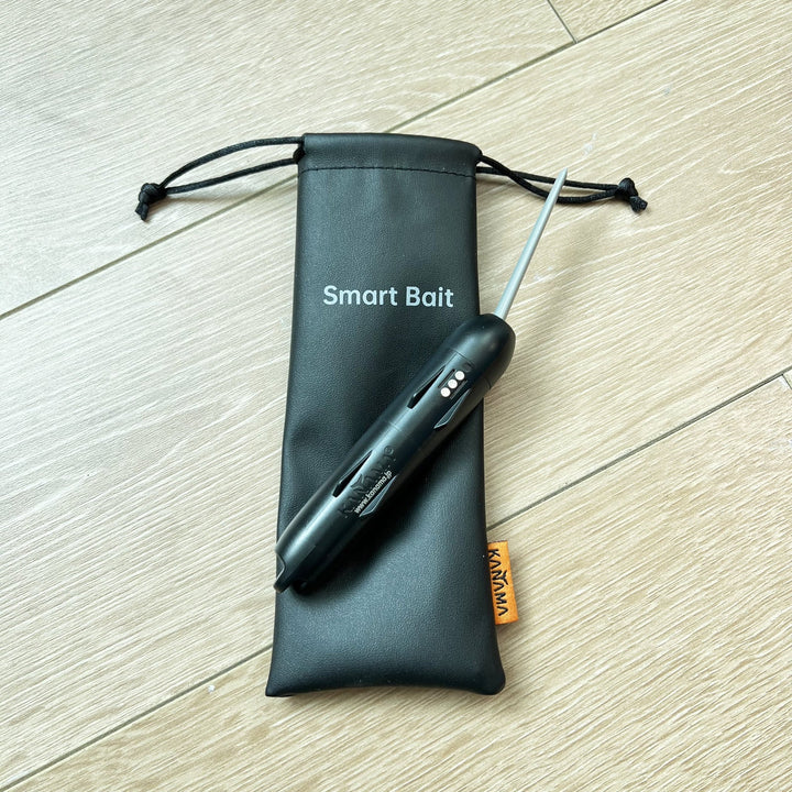 The black bag labeled "Smart Bait" has been opened and there is an orange label with "KANAMA" printed on the edge of the bag. A Smart Bait is placed on the bag.